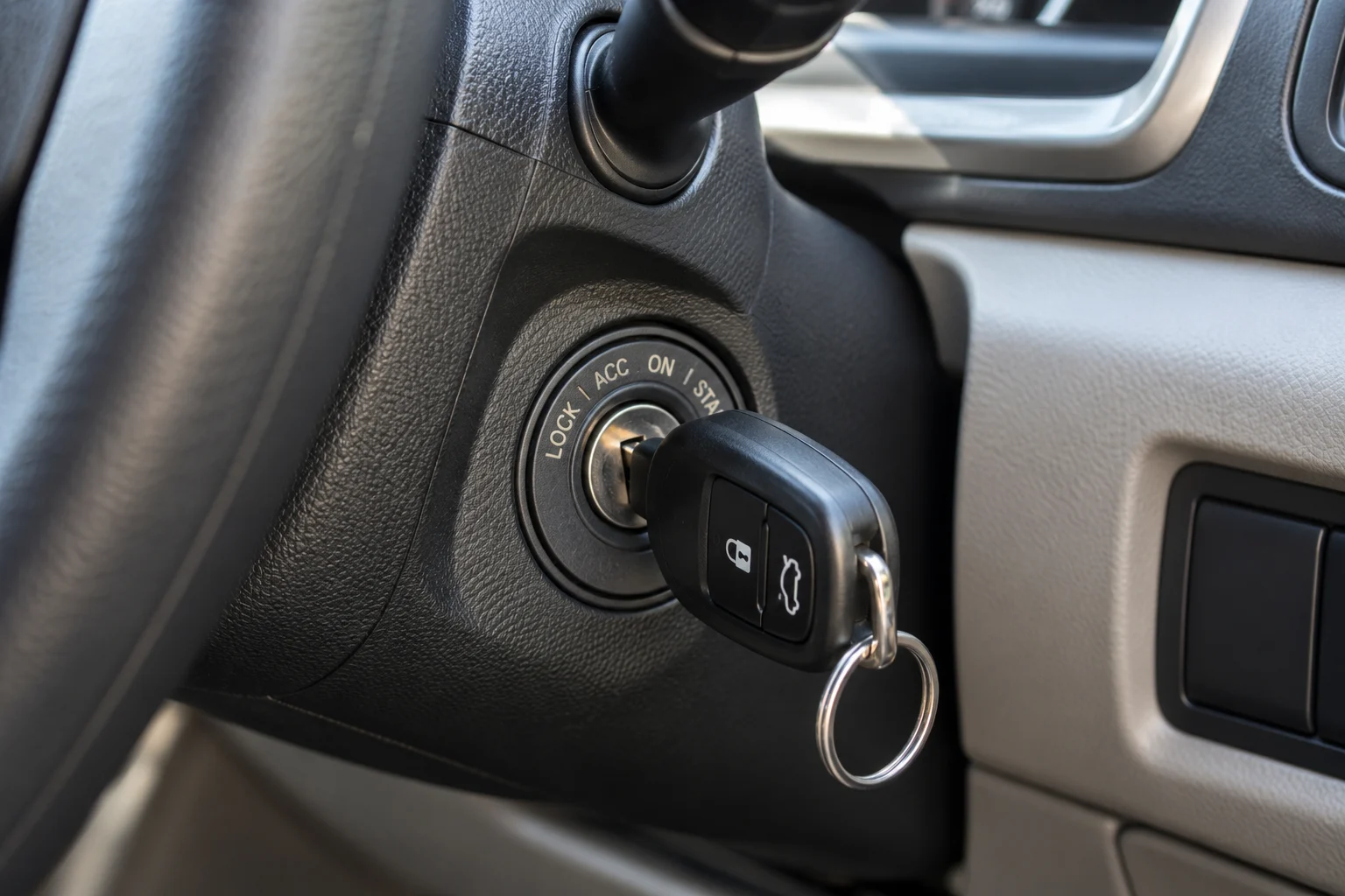 Car ignition cylinder with key beside the steering column