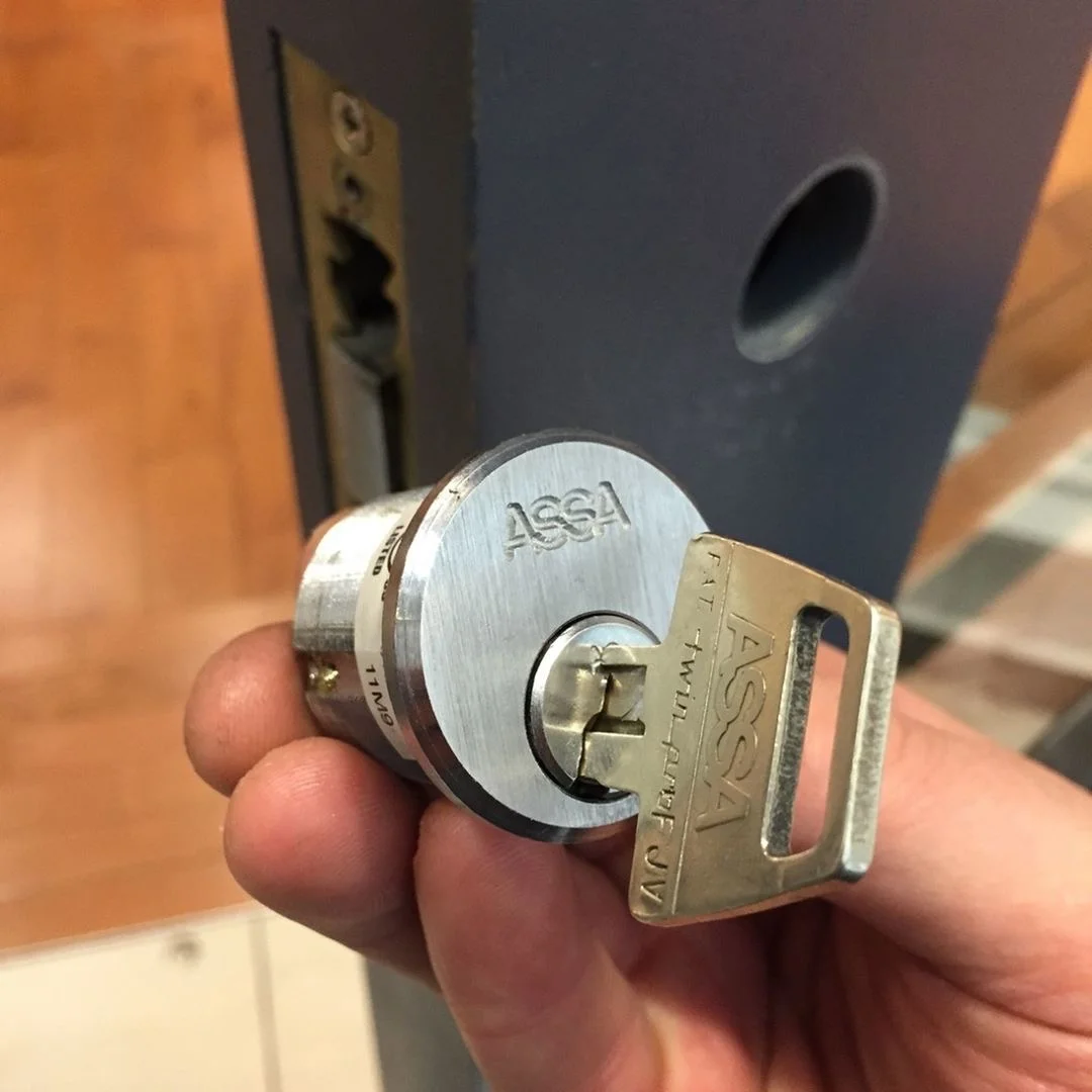 ASSA cylinder and key beside a door