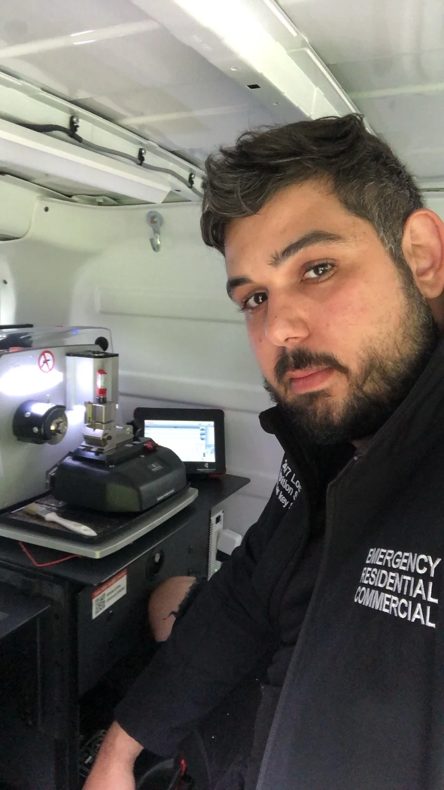 Star Locksmith technician beside key-cutting equipment in a service van