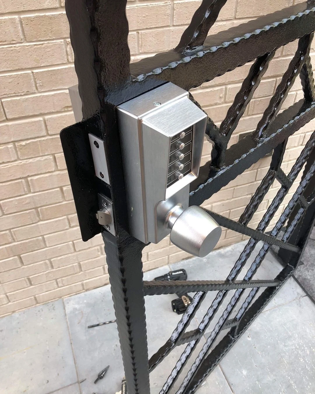 Mechanical pushbutton lock installed on an iron gate